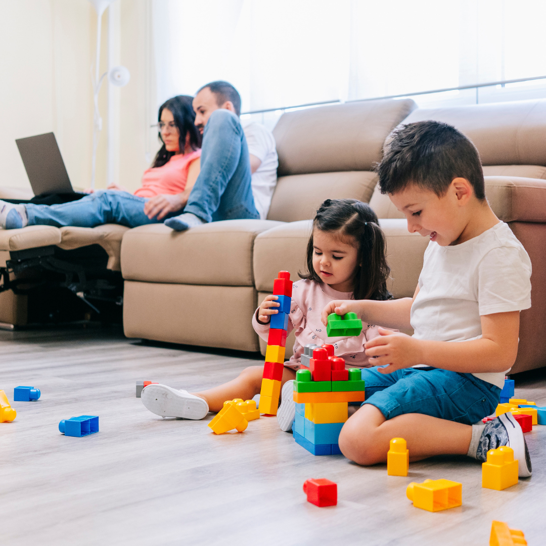 Parents doing school choice paperwork while child is playing.